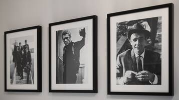 Drie zwart-witfoto's in lijsten aan een muur.