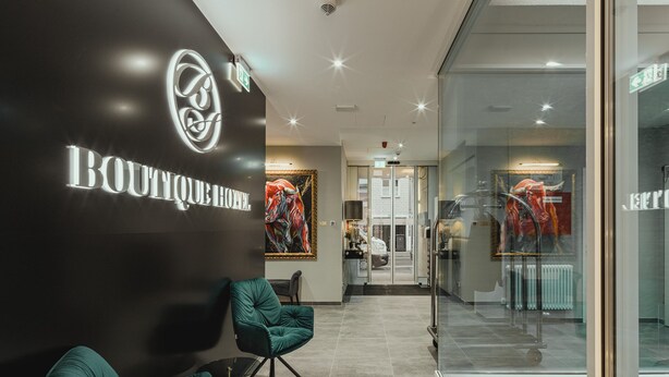 A modern hotel lobby with a prominent 'Boutique Hotel' sign, comfortable seating, and a glass entrance leading to the reception area. - BS Boutique Hotel (Heidelberg)
