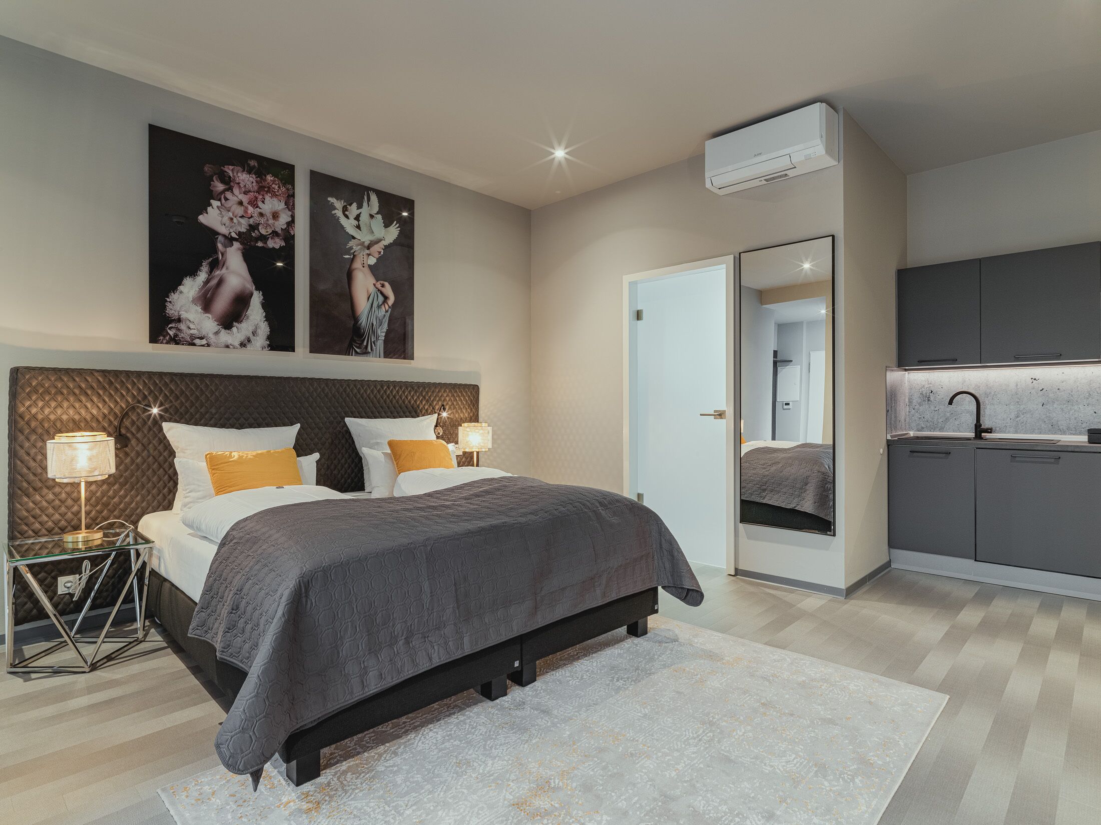 A modern bedroom with a large bed, bedside lamps, and artwork on the wall.