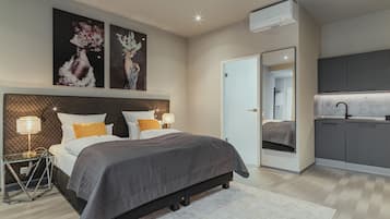 A modern bedroom with a large bed, bedside lamps, and artwork on the wall.