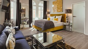 A modern hotel room with a bed, sofa, and a glass coffee table. - BS Boutique Hotel (Heidelberg)