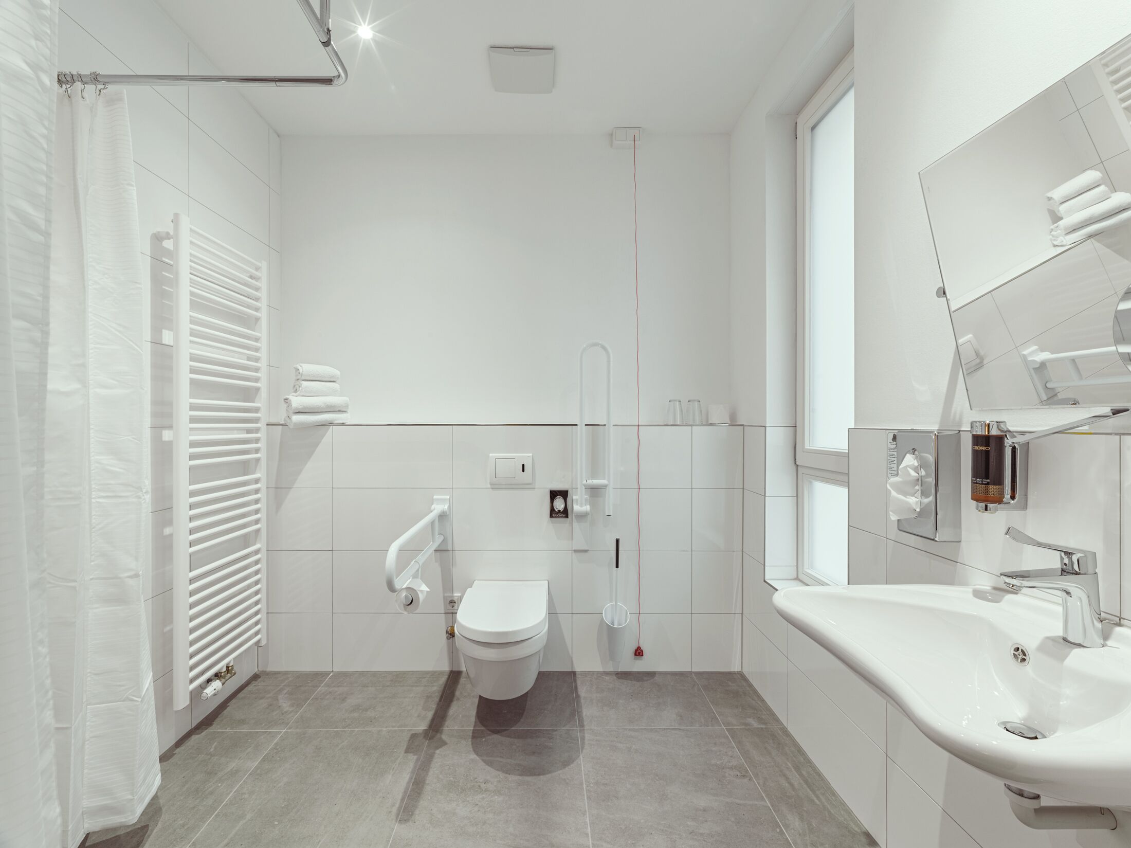 A modern bathroom with a toilet, bidet, and sink.