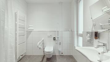 A modern bathroom with a toilet, bidet, and sink.