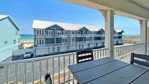 A beachfront hotel with multiple balconies, a covered outdoor area, and a view of the beach.