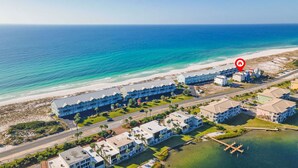 A coastal hotel with multiple buildings, a beach, and a marina.