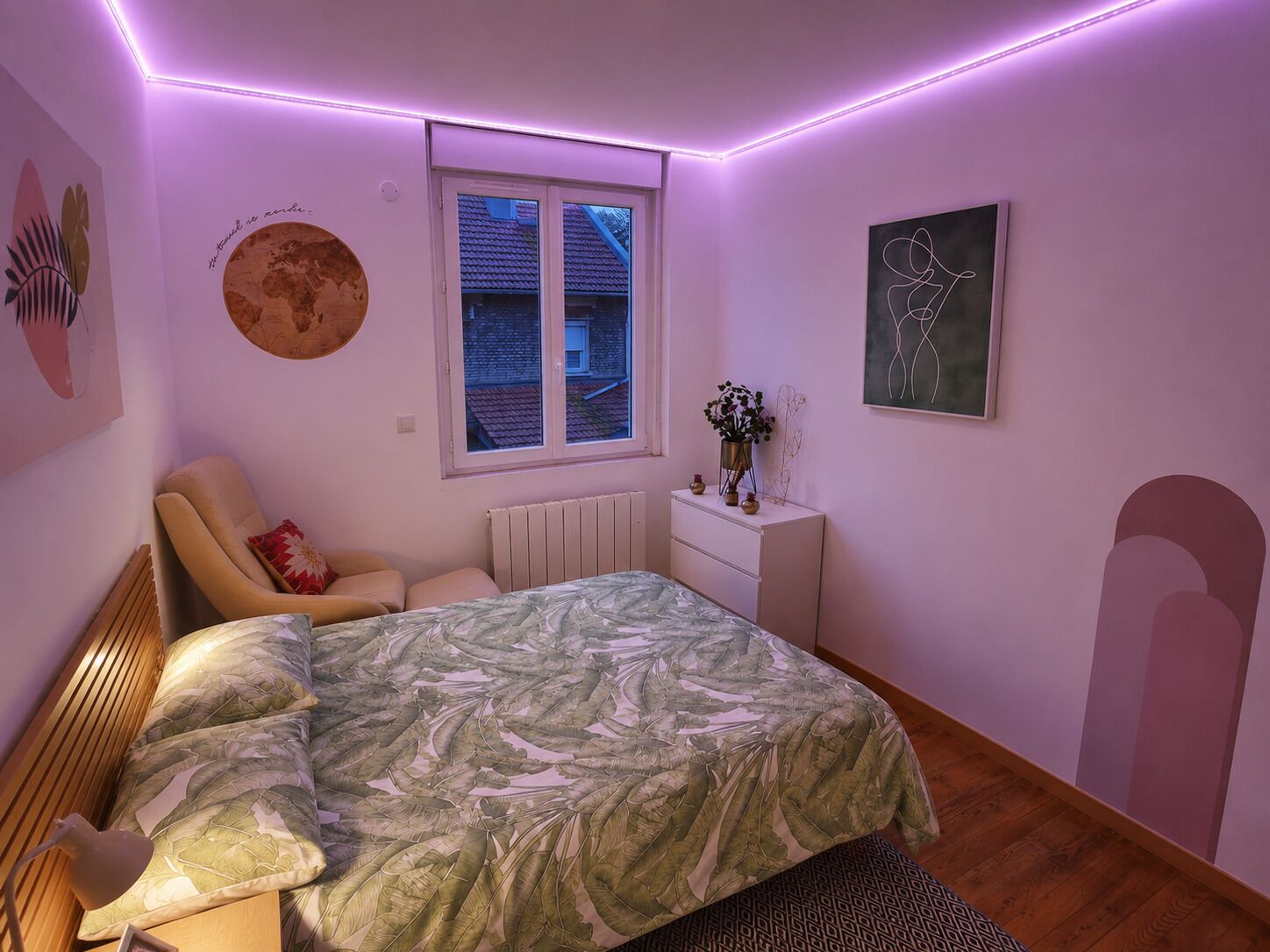 Une chambre à coucher comprenant un lit, une chaise, une commode, une fenêtre et des éléments de décoration murale.