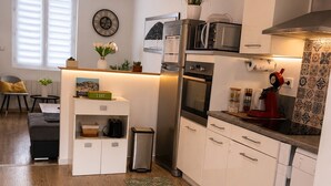 A modern kitchen with white cabinetry, a built-in oven, and a coffee machine. - Luxury, peaceful, 3 bedroom family home (Saint-Quentin)