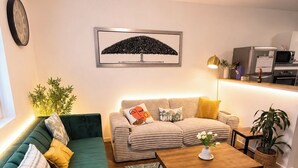 A living room with a green sofa, a beige sofa, a wooden coffee table, and a patterned rug. - Luxury, peaceful, 3 bedroom family home (Saint-Quentin)
