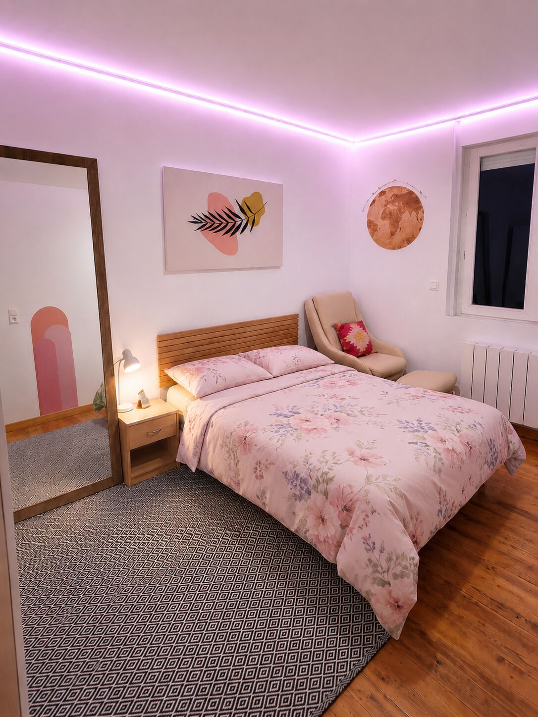 Un dormitorio con cama, mesita de noche, silla y espejo.