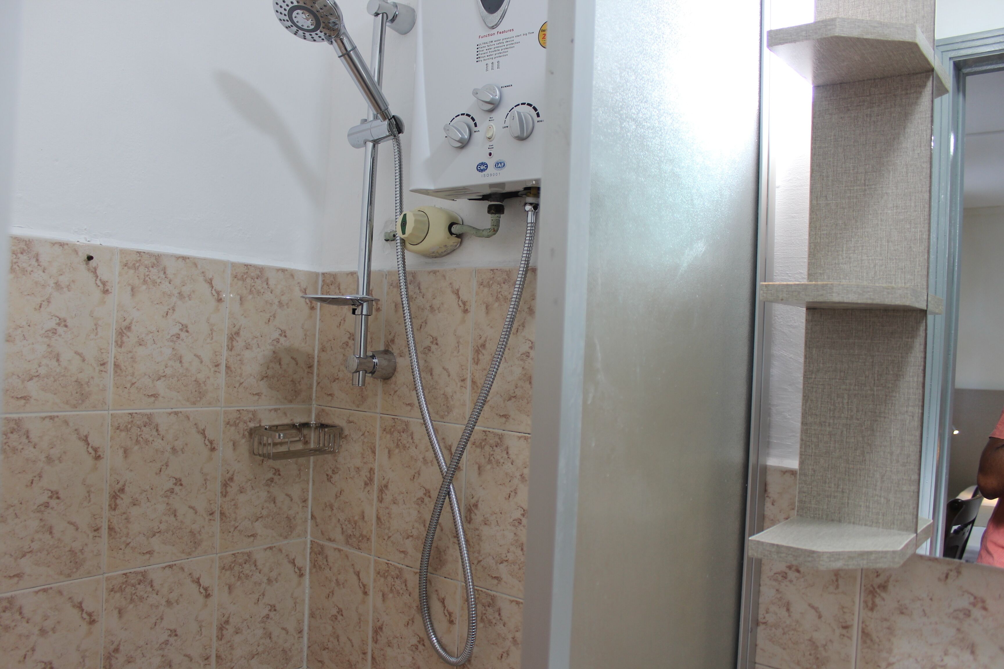 Ein Badezimmer mit Dusche, Bedienfeld und Handtuchhalter.