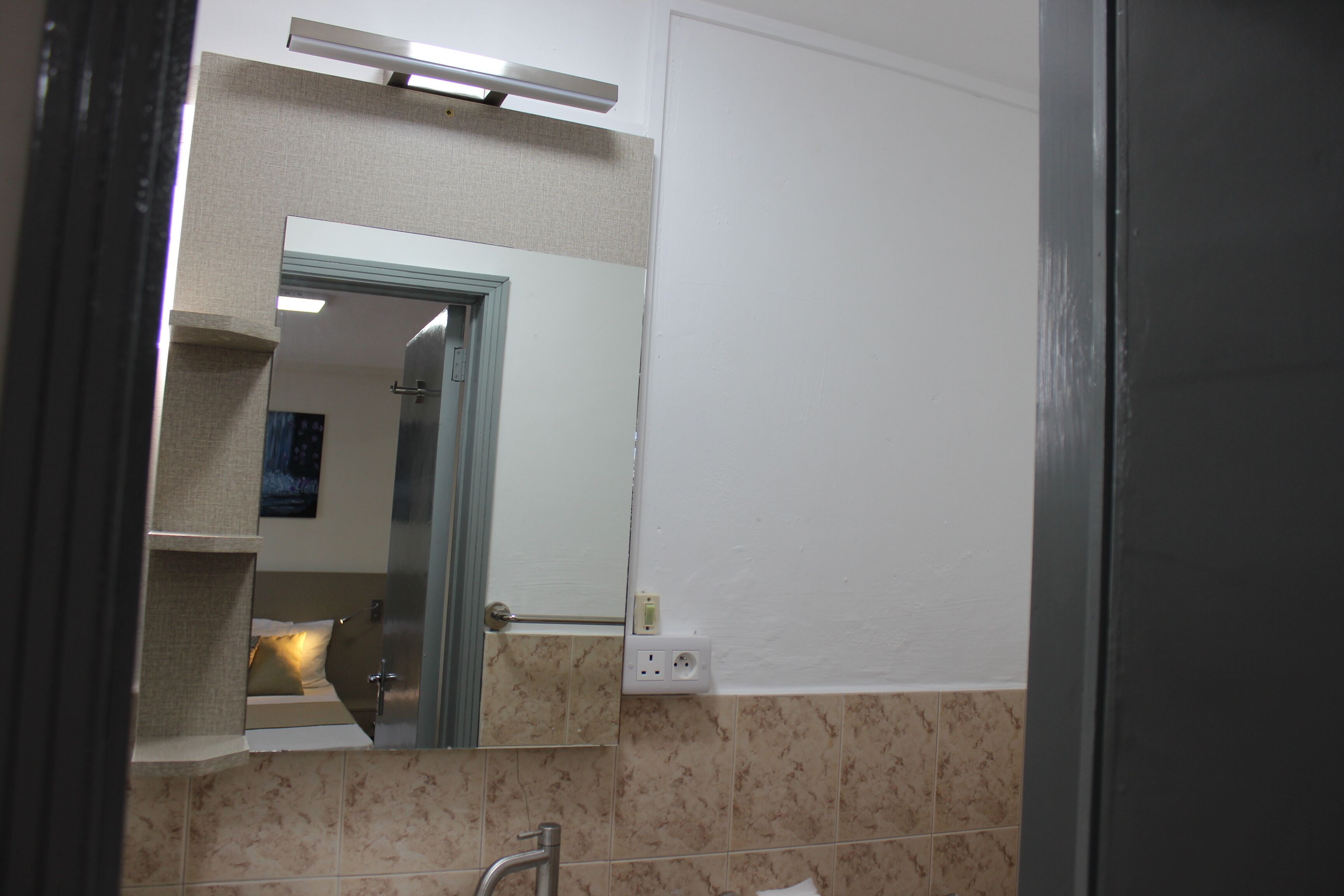 Un baño con espejo, toallero y retrete.