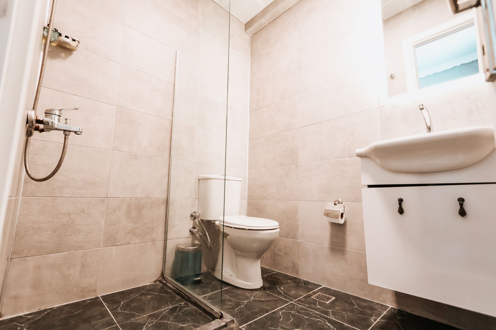Ein Badezimmer mit Dusche, Toilette und Waschbecken.