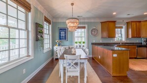 Una cocina amplia con una isla grande, armarios de madera y un candelabro.