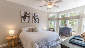 Ein Schlafzimmer mit Bett, Nachttischen, einem Schminktisch und Bildern an der Wand.