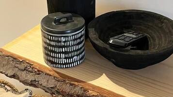 A kitchen counter with a black pot, a patterned container, and a black bowl.
