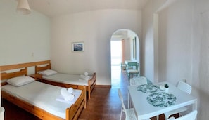 Habitación cuádruple panorámica, vista al mar | Tabla de planchar con plancha, wifi gratis y ropa de cama 