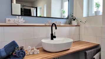 Een douche, handdoeken, zeep, toiletpapier