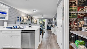 A modern kitchen with white cabinetry, a stainless steel dishwasher, and a central island. - Charming 2 Bed 2 Bath True Blue Pawleys Island Golf, 4 Pools Beach 5 min drive! (Pawleys Island)