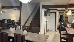 Una sala moderna con escalera, comedor y cocina.