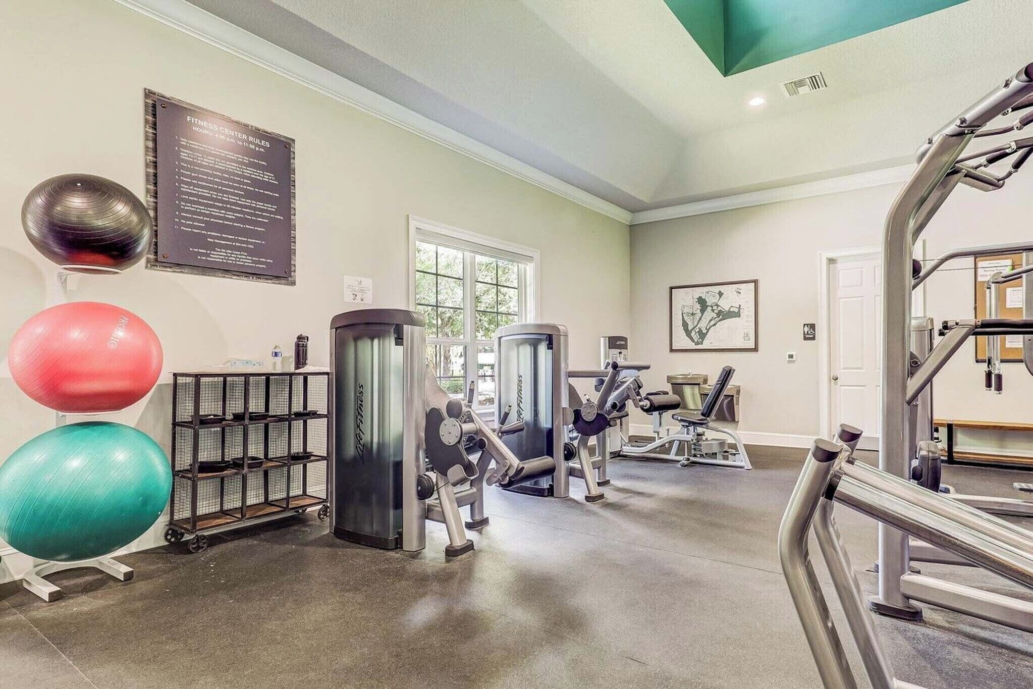 A fitness center with exercise equipment, a rack of weights, and exercise balls.