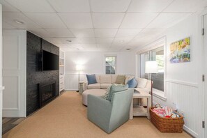 Ein Wohnzimmer mit Kamin, Sofa und Fernseher.
