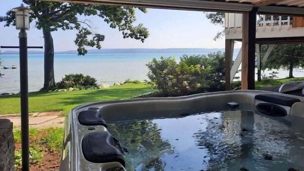 A hot tub with a view of a lake and mountains. - Big Glen Lakefront with Hot Tub and Two Fireplaces! (Glen Arbor)