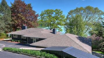 Une maison à deux étages avec un toit en pente, une cheminée et un garage.