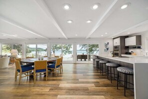 Uma cozinha moderna com área de bar, grandes janelas e espaço de jantar com vista.