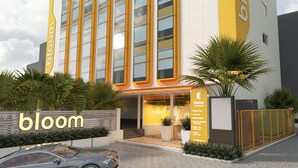 A modern hotel with a prominent 'bloom' sign, large windows, and a checkered entrance. - Bloom Hotel - Gachibowli (Hyderabad)