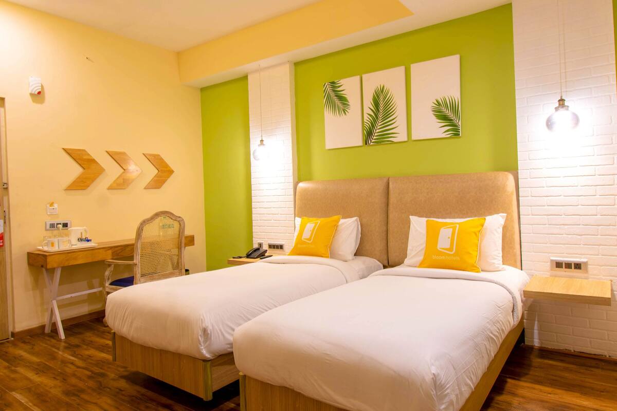Habitación de hotel con dos camas, un escritorio y una silla.