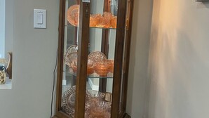 Eine Holzwettrine mit Glastüren, die verschiedene Gläser beherbergt.