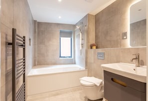 Bathtub, hair dryer, towels, shampoo