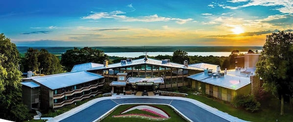 A hotel with a central building, multiple wings, and a landscaped area with a flower bed.