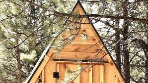 Una cabaña de madera con techo triangular, número 3, y una planta colgante.