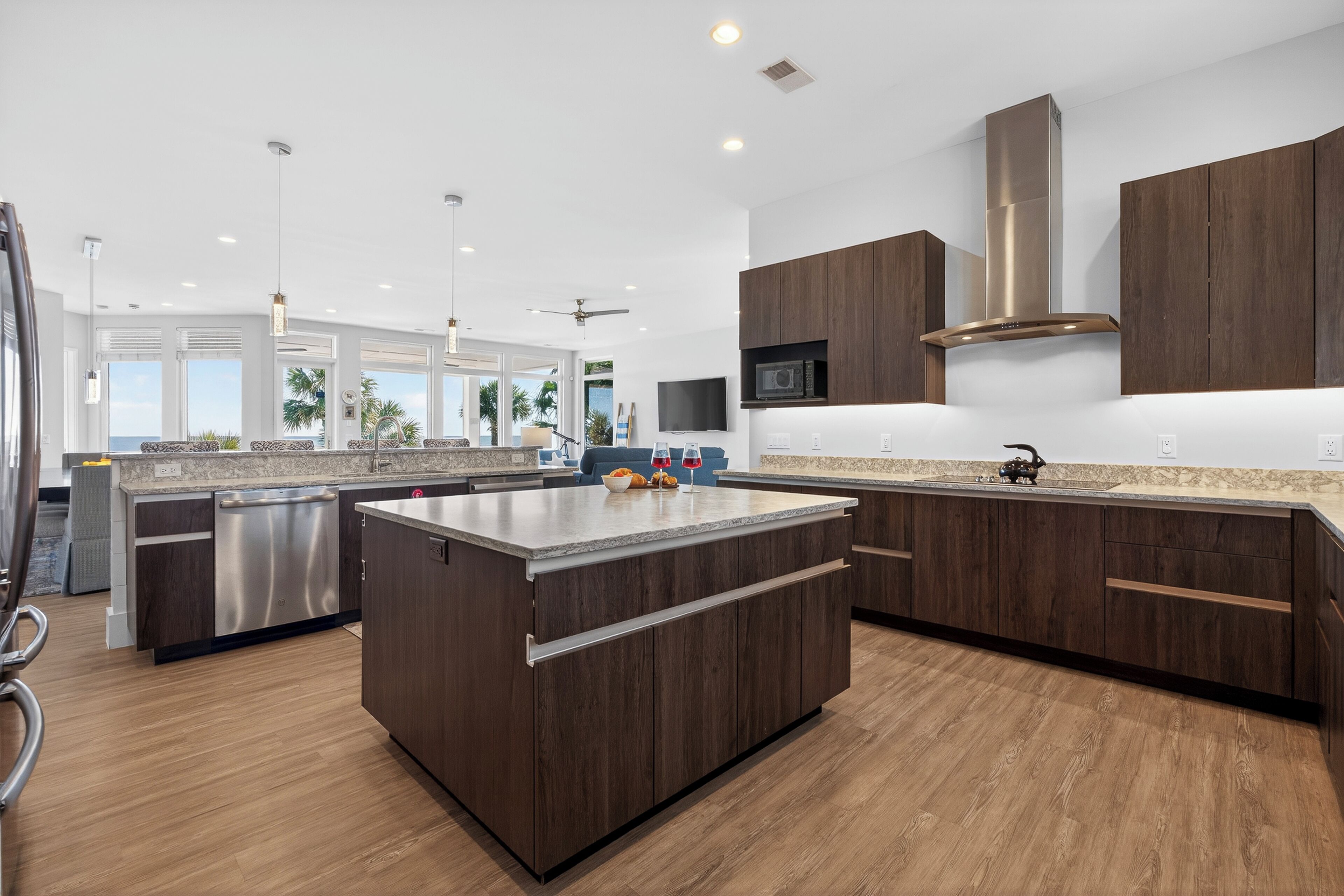 A modern kitchen with dark wood cabinets, stainless steel appliances, and a large island.