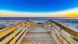 A wooden boardwalk leading to a beach with a clear sky. - Newly Built 7-bedroom Oceanfront Stunner with private pool. (Hilton Head Island)