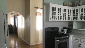A kitchen with wooden flooring, a stove, white cabinets, and a microwave. - Beautiful, tranquil Home. 8 minutes from the International Airport (Vieux Fort)