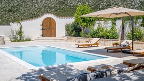 A pool area with lounge chairs and a wooden door, surrounded by greenery and a hillside. - Villa Little Paradise with a private pool, 4 bedrooms, 2 living areas, 3km from the beach in Marina (Marina)