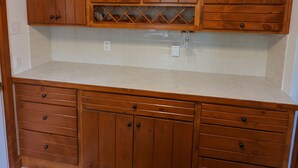 Una cucina con mobili in legno, un piano di lavoro e una schiena di rivestimento.
