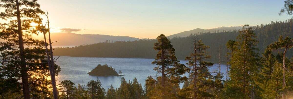 A lake surrounded by trees and mountains.
