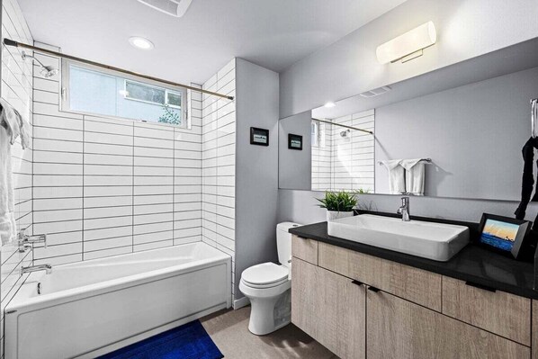 Un baño moderno con bañera, inodoro y lavabo.