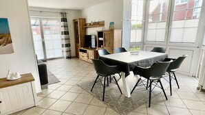 Un coin repas comprenant une table et des chaises, un téléviseur et un meuble.