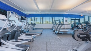 A gym with multiple treadmills, ellipticals, and a stationary bike.