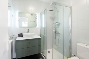 A modern bathroom with a glass-enclosed shower, a white sink, and a mirror above it. - Happyfew la suite Fodéré (Nice)