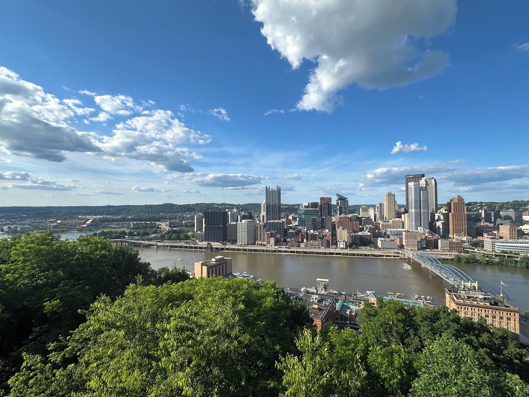 Une vue sur les toits d’une ville, avec des bâtiments modernes, une rivière et un pont.