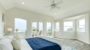 A bedroom with a bed, a ceiling fan, and large windows. - 2nd row Gulf Views w/ Large Deck, Open Living, Private Bedrooms - Cool & Coastal (Galveston)