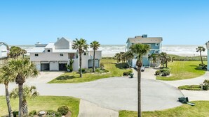 A residential area with houses, palm trees, and a view of the ocean. - 2nd row Gulf Views w/ Large Deck, Open Living, Private Bedrooms - Cool & Coastal (Galveston)