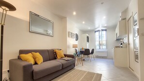 A modern living room with a sofa, a coffee table, and a dining area with chairs and a table. - N&J - L'ANCRE - Port district - Close Old Town (Niza)