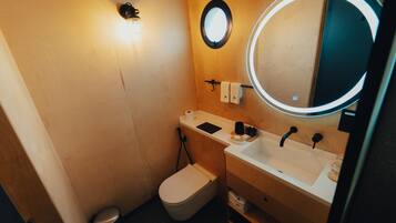 Un baño pequeño con inodoro, lavabo y espejo.