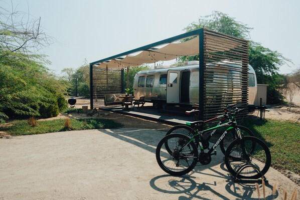 A camper with a covered outdoor seating area and a bicycle parked nearby. -  Bab Al Nojoum Al Mugheirah (Al Mirfa)